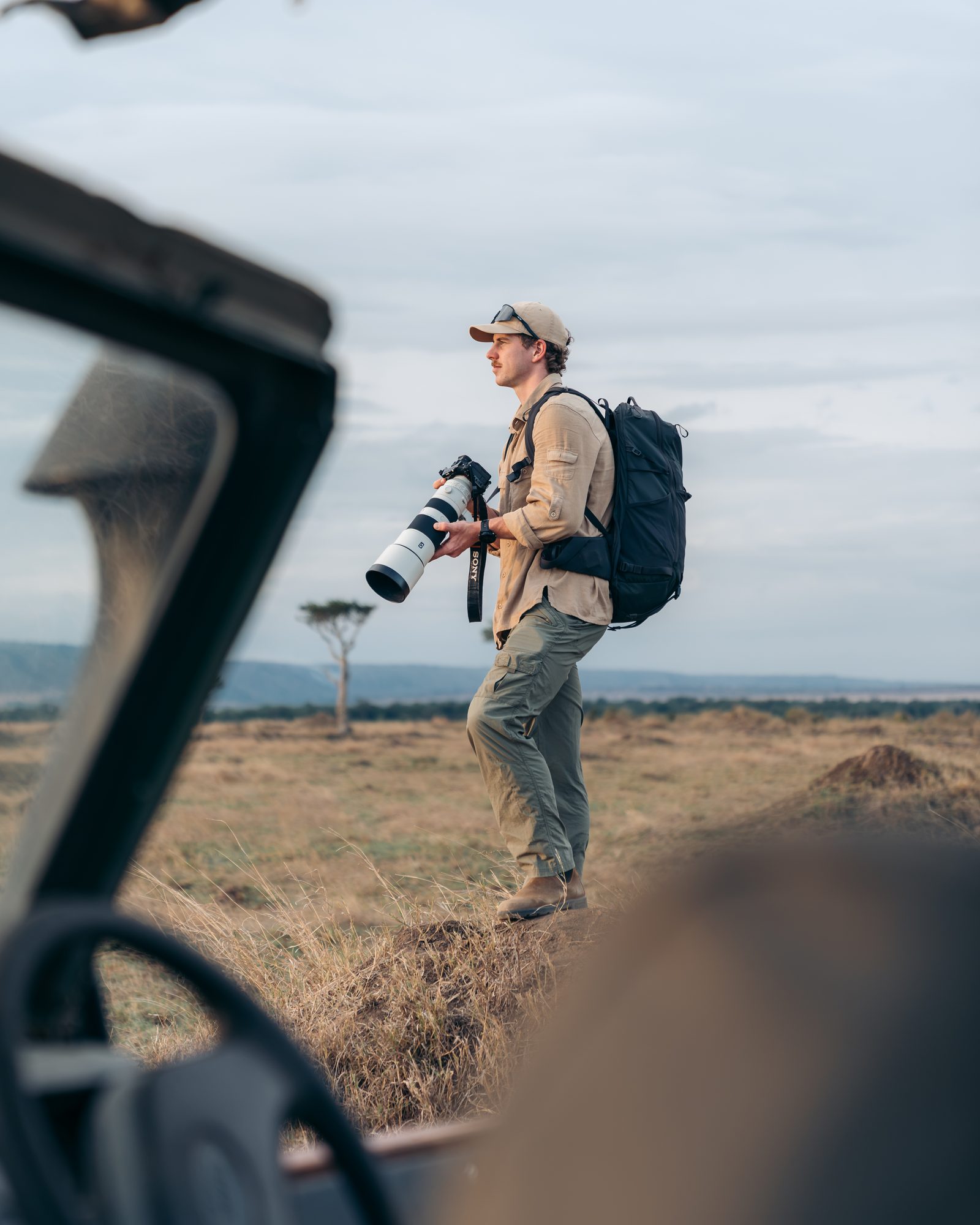 Charlie walking with a camera in the Maasai Mara